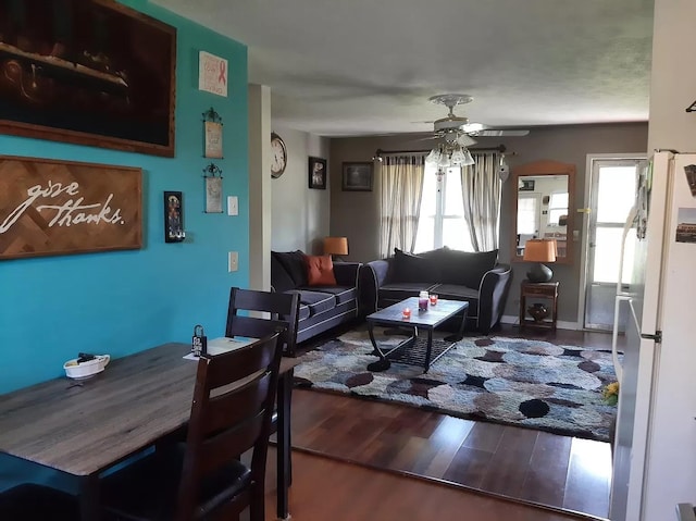 living area with ceiling fan, wood finished floors, and a wealth of natural light