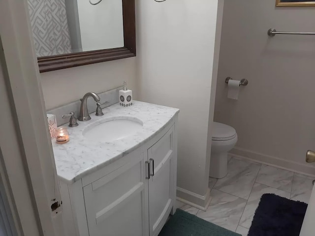 half bathroom featuring marble finish floor, toilet, vanity, and baseboards
