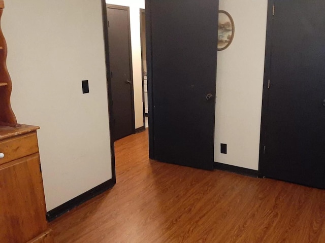 interior space with baseboards and wood finished floors