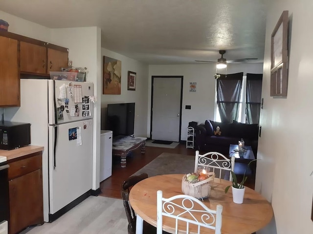 dining space featuring ceiling fan and light wood-style flooring