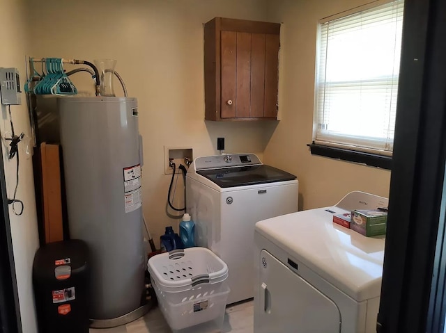 laundry area with cabinet space, electric water heater, and washer and dryer