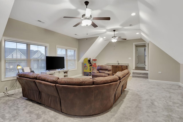 living room featuring light colored carpet, visible vents, vaulted ceiling, ceiling fan, and baseboards