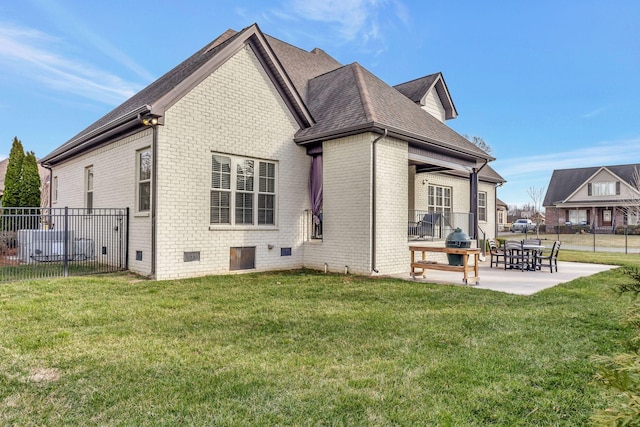 rear view of house featuring a yard, a patio area, fence, and brick siding