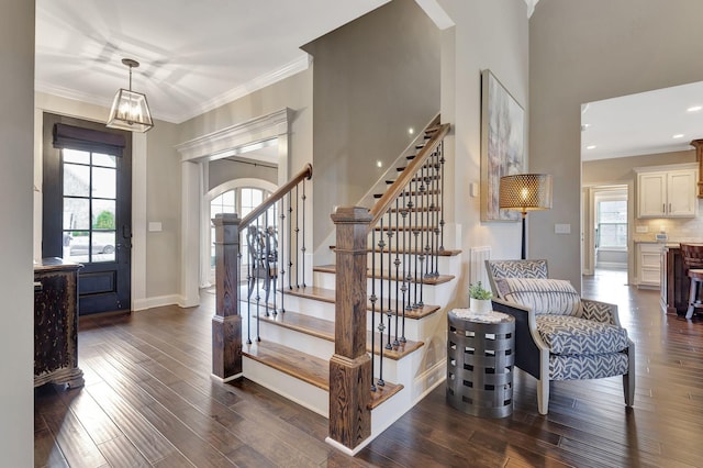 entryway with ornamental molding, dark wood-style flooring, and plenty of natural light