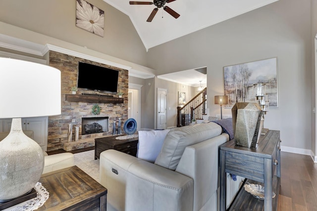 living room featuring a fireplace, wood finished floors, baseboards, stairway, and crown molding