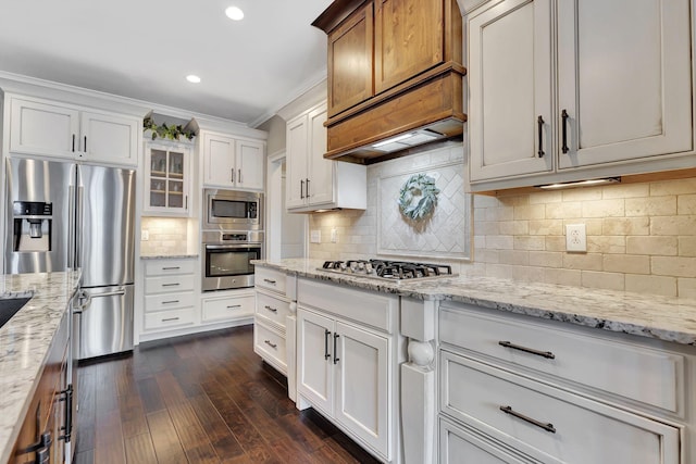 kitchen featuring dark wood-type flooring, white cabinets, appliances with stainless steel finishes, custom exhaust hood, and crown molding