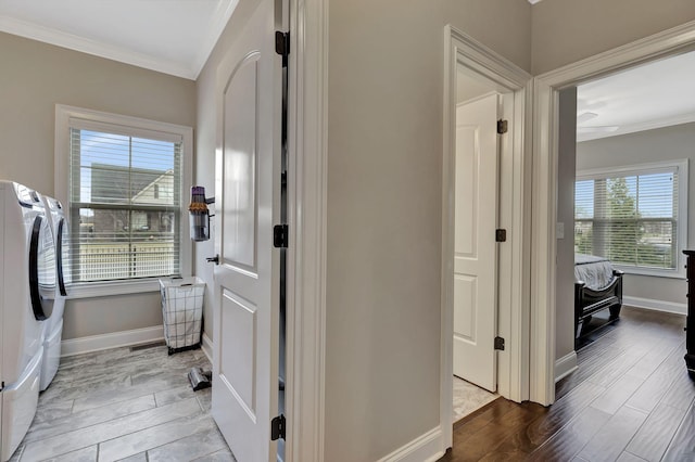 hallway featuring wood tiled floor, baseboards, crown molding, and washing machine and clothes dryer