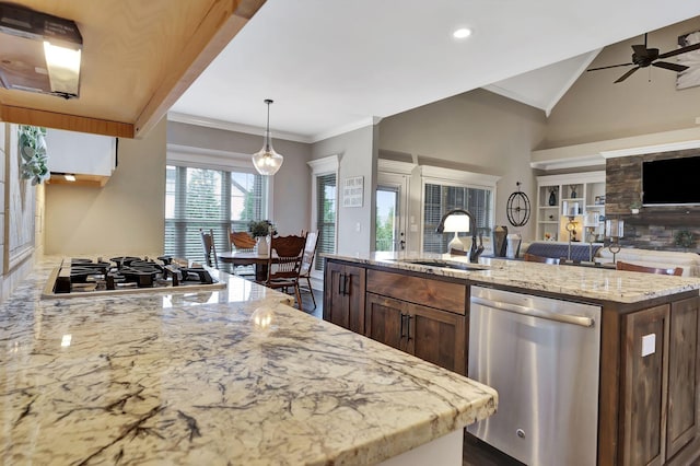 kitchen featuring appliances with stainless steel finishes, open floor plan, crown molding, and a sink