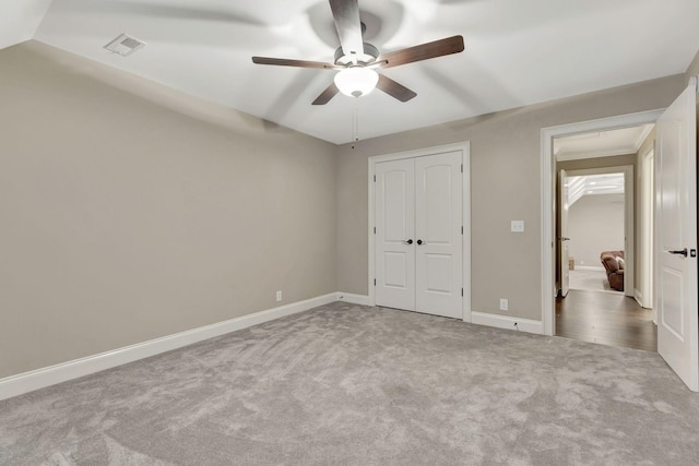 unfurnished bedroom featuring carpet, a closet, visible vents, a ceiling fan, and baseboards