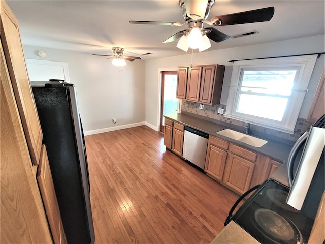 kitchen featuring visible vents, decorative backsplash, appliances with stainless steel finishes, light wood-type flooring, and a sink