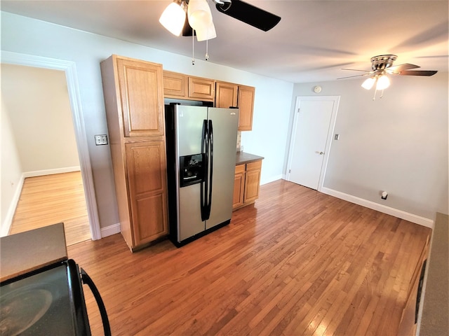 kitchen featuring baseboards, ceiling fan, stainless steel refrigerator with ice dispenser, and light wood-style floors