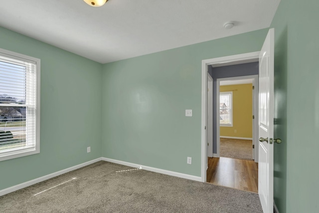 carpeted spare room featuring baseboards