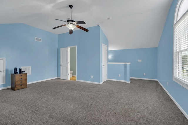 interior space with lofted ceiling, carpet floors, baseboards, and visible vents