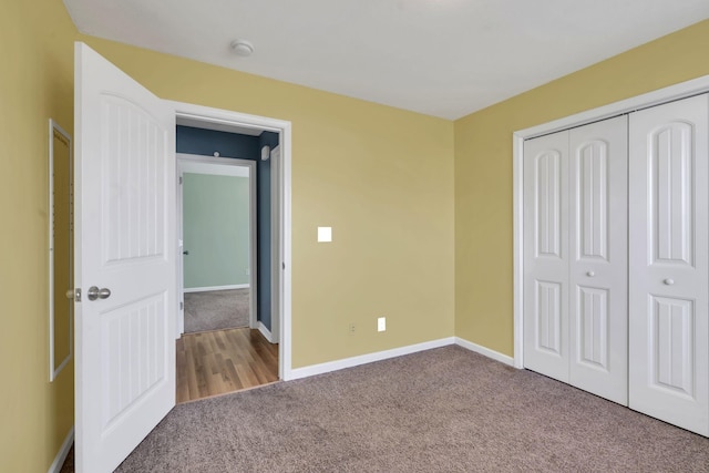 unfurnished bedroom with carpet, baseboards, and a closet