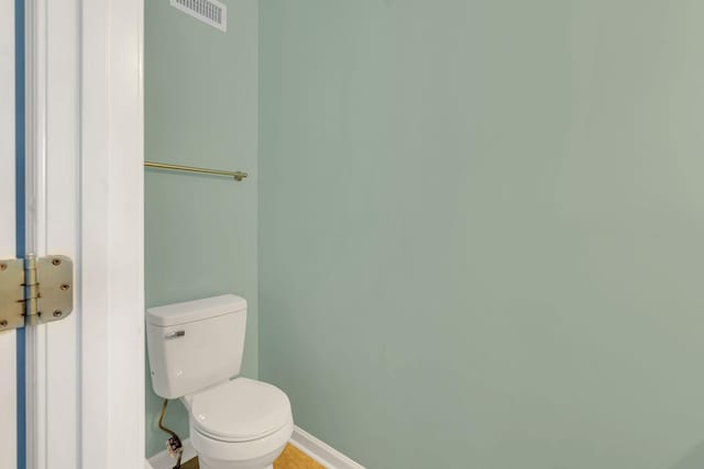 bathroom featuring toilet, baseboards, and visible vents