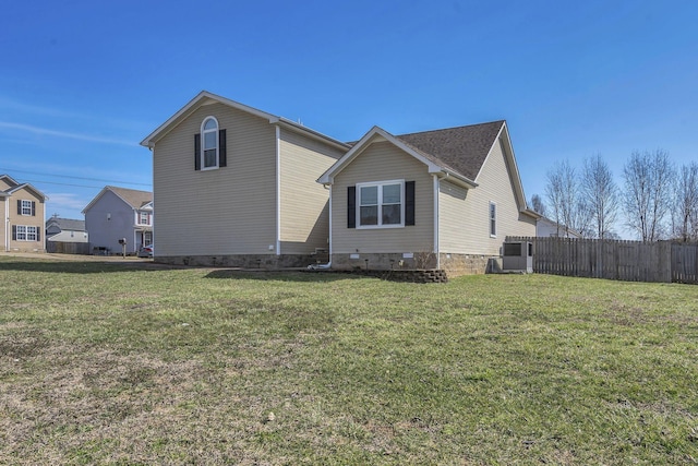 view of side of home featuring a yard, crawl space, and fence