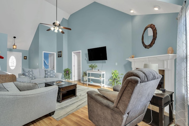 living room featuring high vaulted ceiling, ceiling fan, and wood finished floors