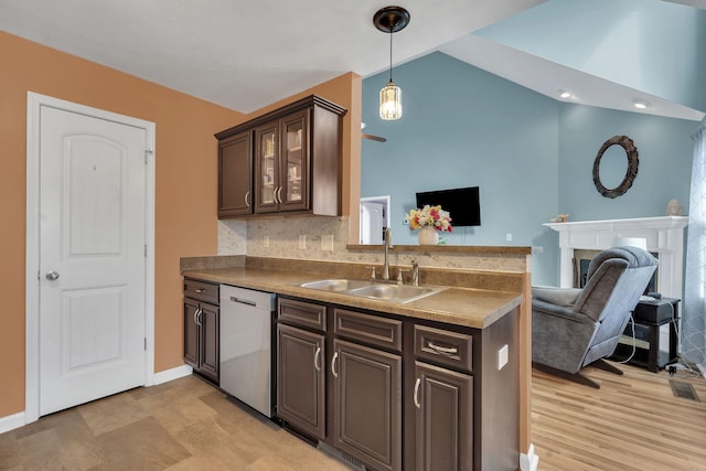 kitchen featuring dishwasher, lofted ceiling, glass insert cabinets, open floor plan, and a sink