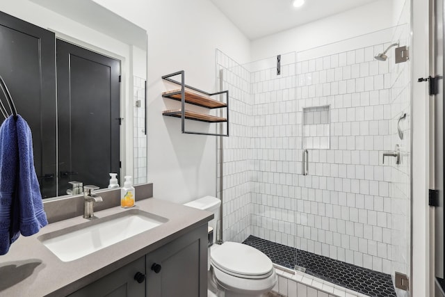 bathroom with a stall shower, vanity, and toilet