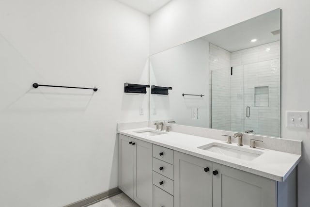 bathroom featuring a sink, a shower stall, baseboards, and double vanity