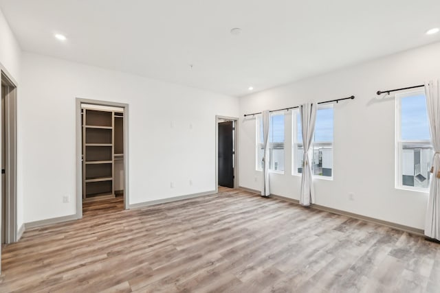 unfurnished bedroom featuring light wood-style floors, recessed lighting, and baseboards