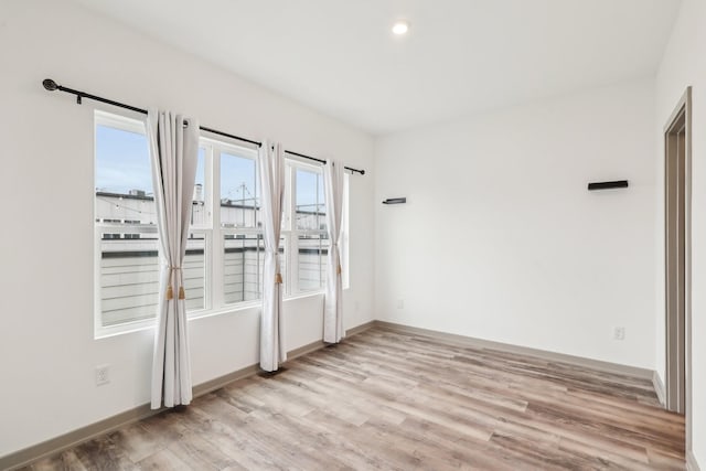 unfurnished room featuring light wood-style flooring and baseboards