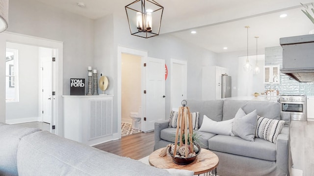 living area with recessed lighting, visible vents, baseboards, and wood finished floors