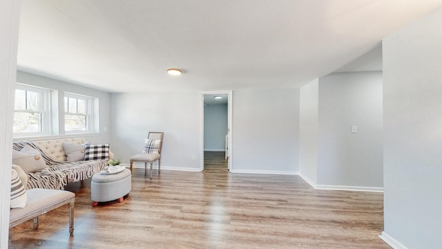 living area with light wood-type flooring and baseboards