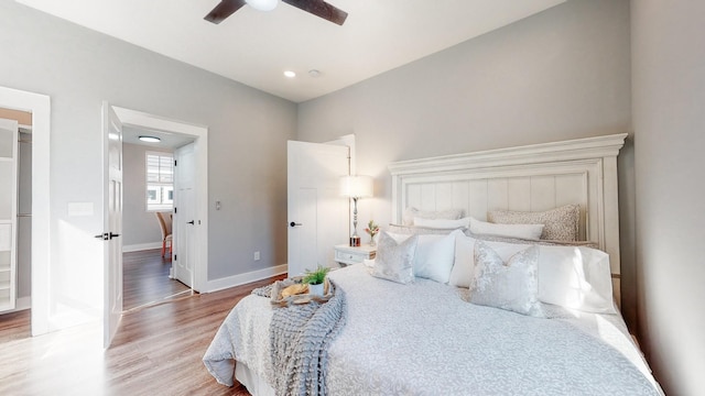 bedroom with a ceiling fan, baseboards, and wood finished floors