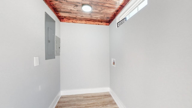 interior space featuring light wood-type flooring, wood ceiling, electric panel, and baseboards