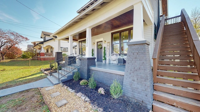 exterior space with covered porch, a yard, fence, and stairs