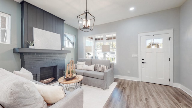 living area with recessed lighting, a brick fireplace, baseboards, and wood finished floors