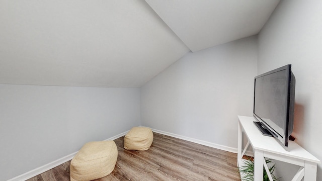 sitting room featuring vaulted ceiling, baseboards, and light wood-style floors