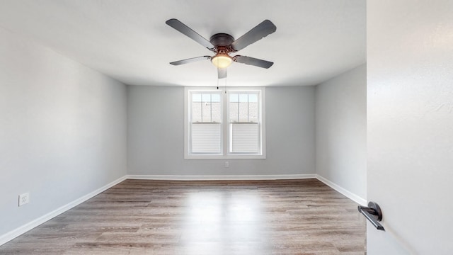 spare room featuring a ceiling fan, baseboards, and wood finished floors