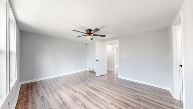 unfurnished room with ceiling fan, baseboards, and wood finished floors