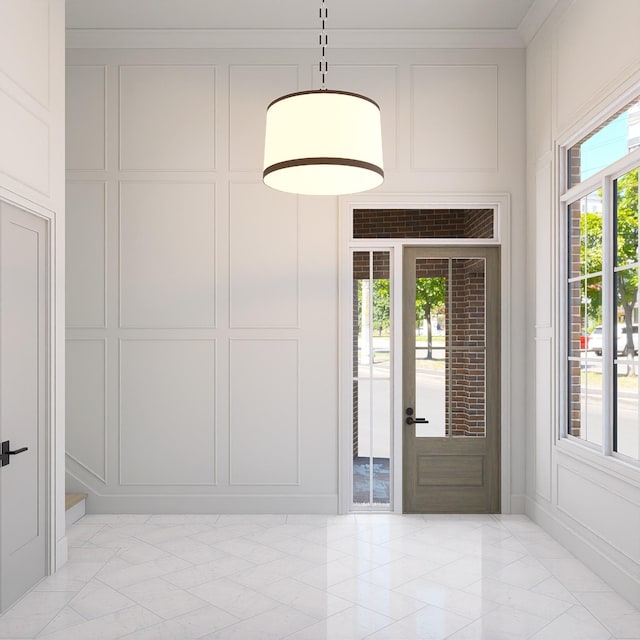 entrance foyer with marble finish floor, ornamental molding, and a decorative wall