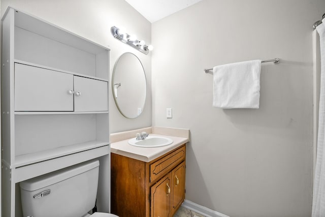 bathroom with toilet, baseboards, and vanity