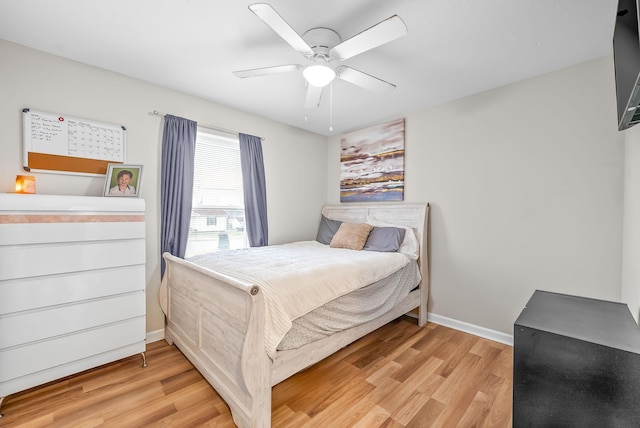 bedroom with ceiling fan, light wood-style flooring, and baseboards