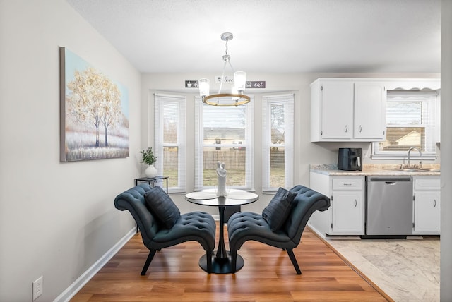 dining room featuring a chandelier, light wood finished floors, and baseboards