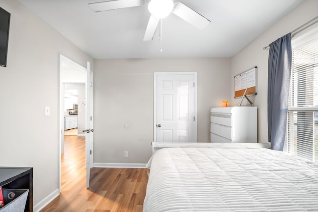 bedroom with ceiling fan, baseboards, and wood finished floors