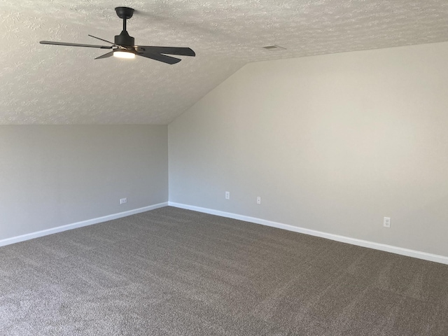 bonus room with dark colored carpet, a ceiling fan, vaulted ceiling, a textured ceiling, and baseboards