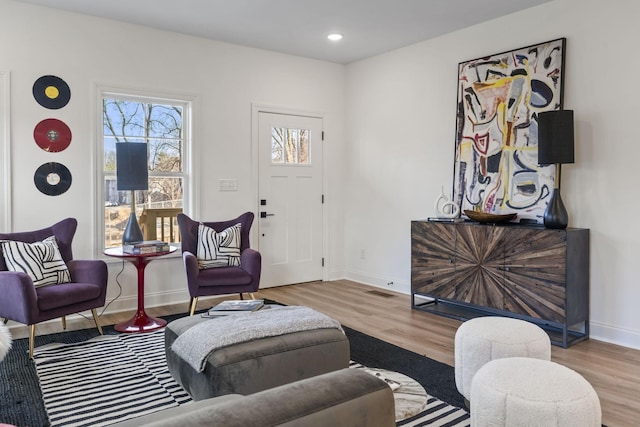 living area featuring recessed lighting, wood finished floors, visible vents, and baseboards