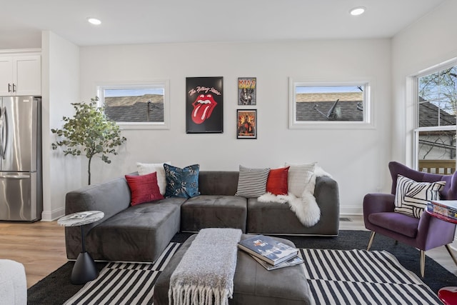 living area with baseboards, wood finished floors, and recessed lighting