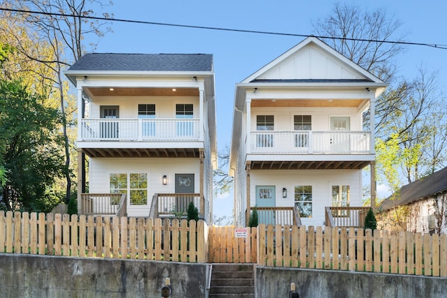 view of front of house featuring a porch, board and batten siding, a fenced front yard, and a balcony