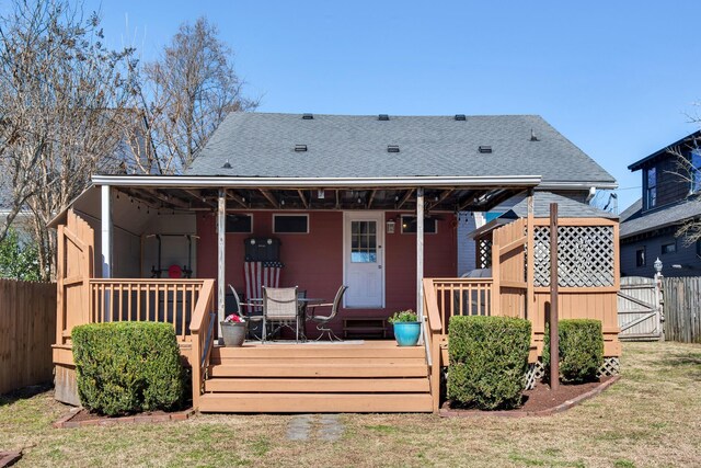 back of house featuring a gate, roof with shingles, fence, and a wooden deck