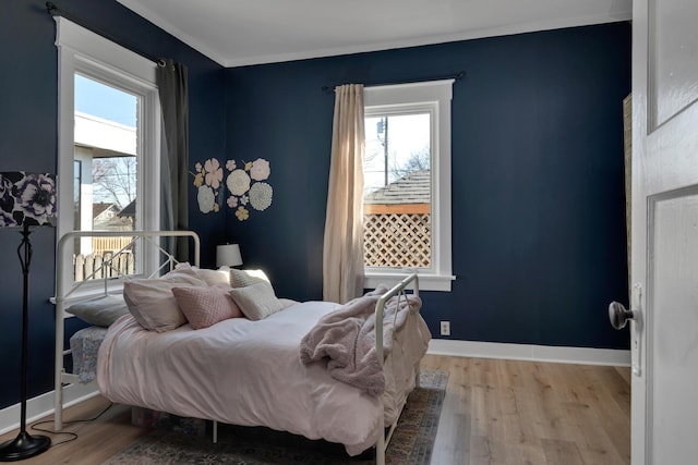 bedroom with baseboards and wood finished floors