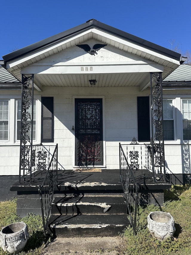 view of exterior entry featuring covered porch