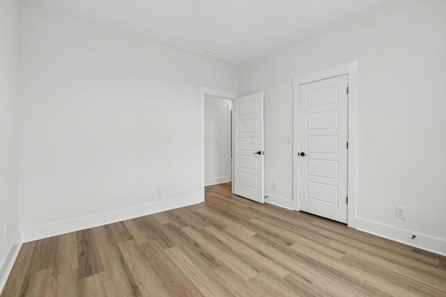 unfurnished bedroom with light wood-style flooring and baseboards