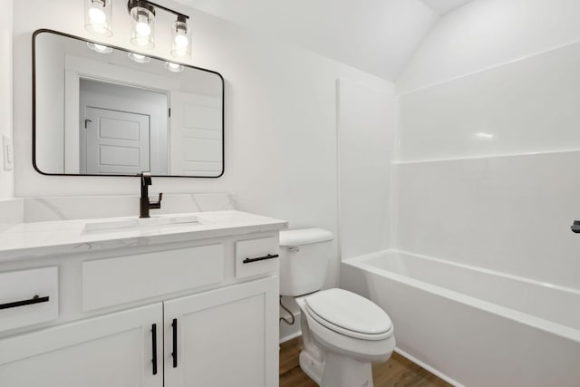 full bathroom with lofted ceiling, wood finished floors, vanity, and toilet