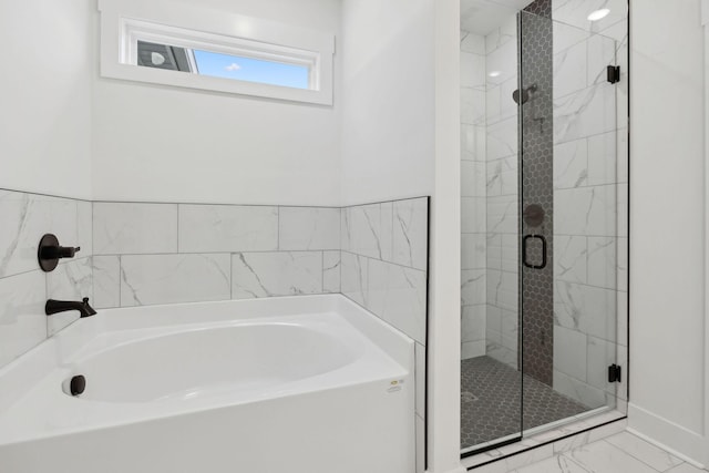 bathroom with marble finish floor, a garden tub, and a shower stall